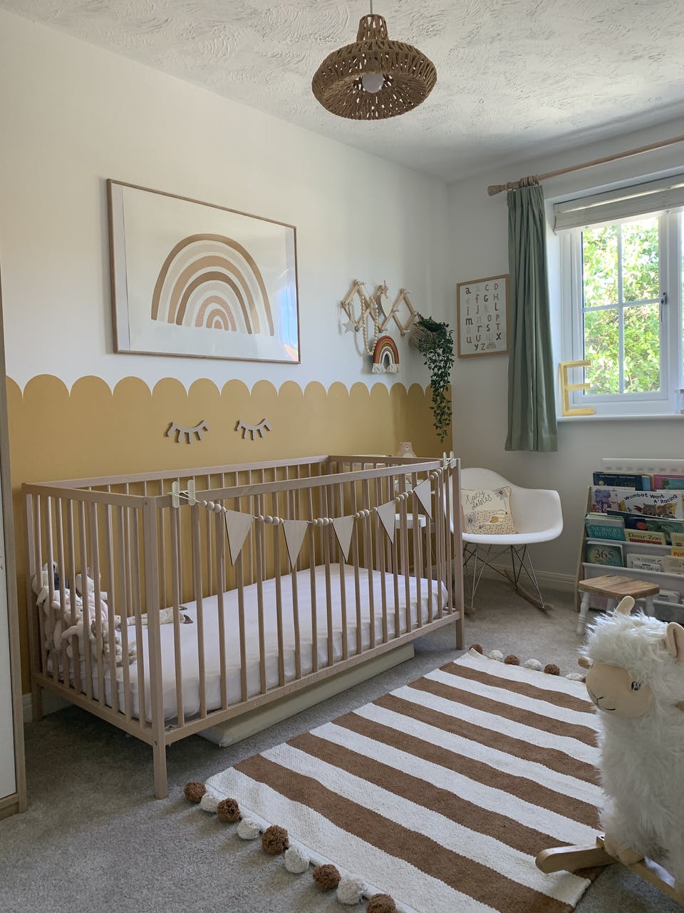 Kids bedroom DIY scalloped mustard coloured border behind cot
