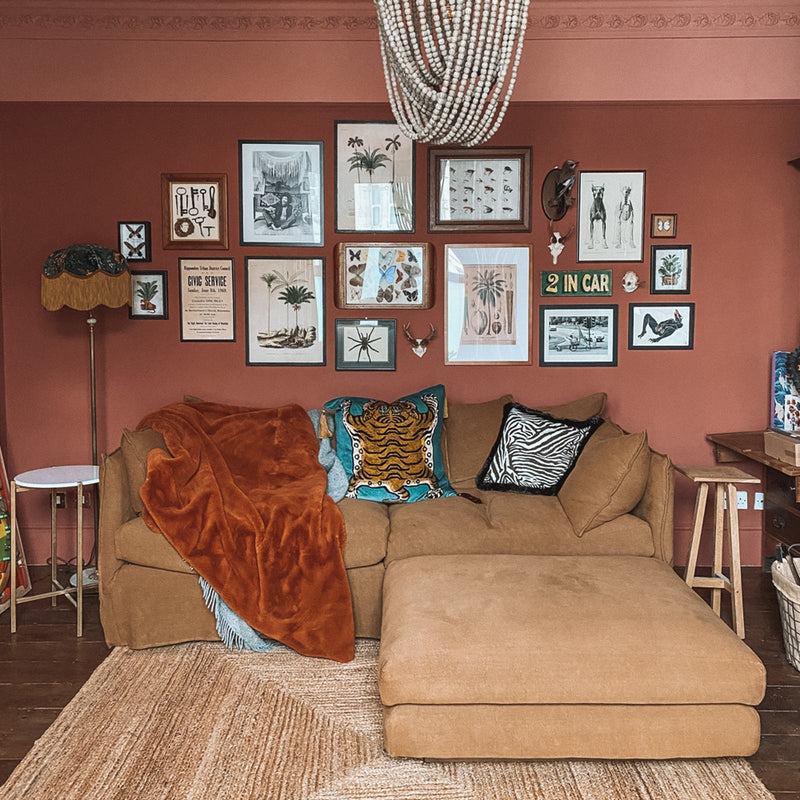 Living room gallery wall with analogous colour scheme featuring walls and ceiling painted in Lick paint Red 03 and Red 01