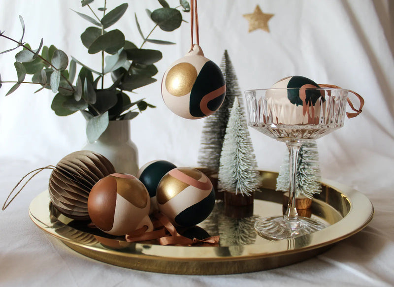 Image of a gold tray with Christmas baubles and mini Christmas tree decorations 