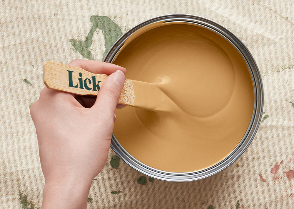 Tin of Lick Yellow 02 paint being stirred